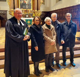 Auf dem Bild sieht man eine Personengruppe vor dem Altar stehen